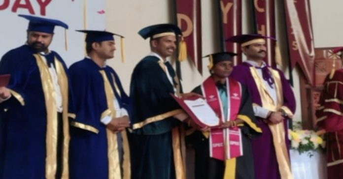 A young woman from Chandurthi receives her graduation certificate.