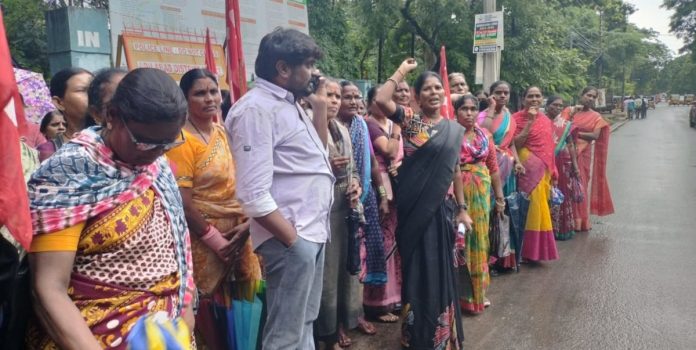 Anganwadi workers protest in front of Adilabad Collectorate in the rain
