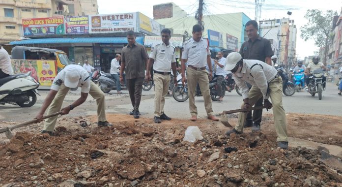 Traffic police remove soil left behind after digging up the road