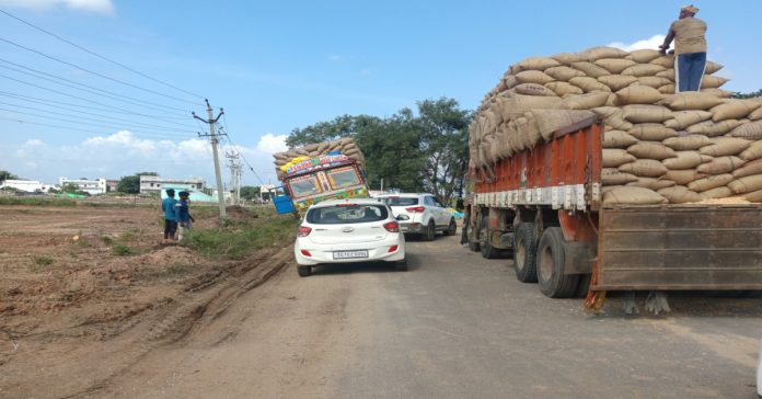 1001912392 A lorry loaded with maize overturned on the side of the road.