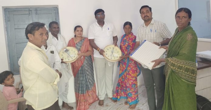 Distribution of wall clocks to 'Indiramma' housing scheme beneficiaries.
