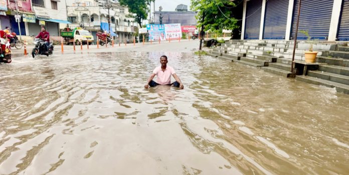 వర్షపు నీటిలో కూర్చొని కౌన్సిలర్ నిరసన